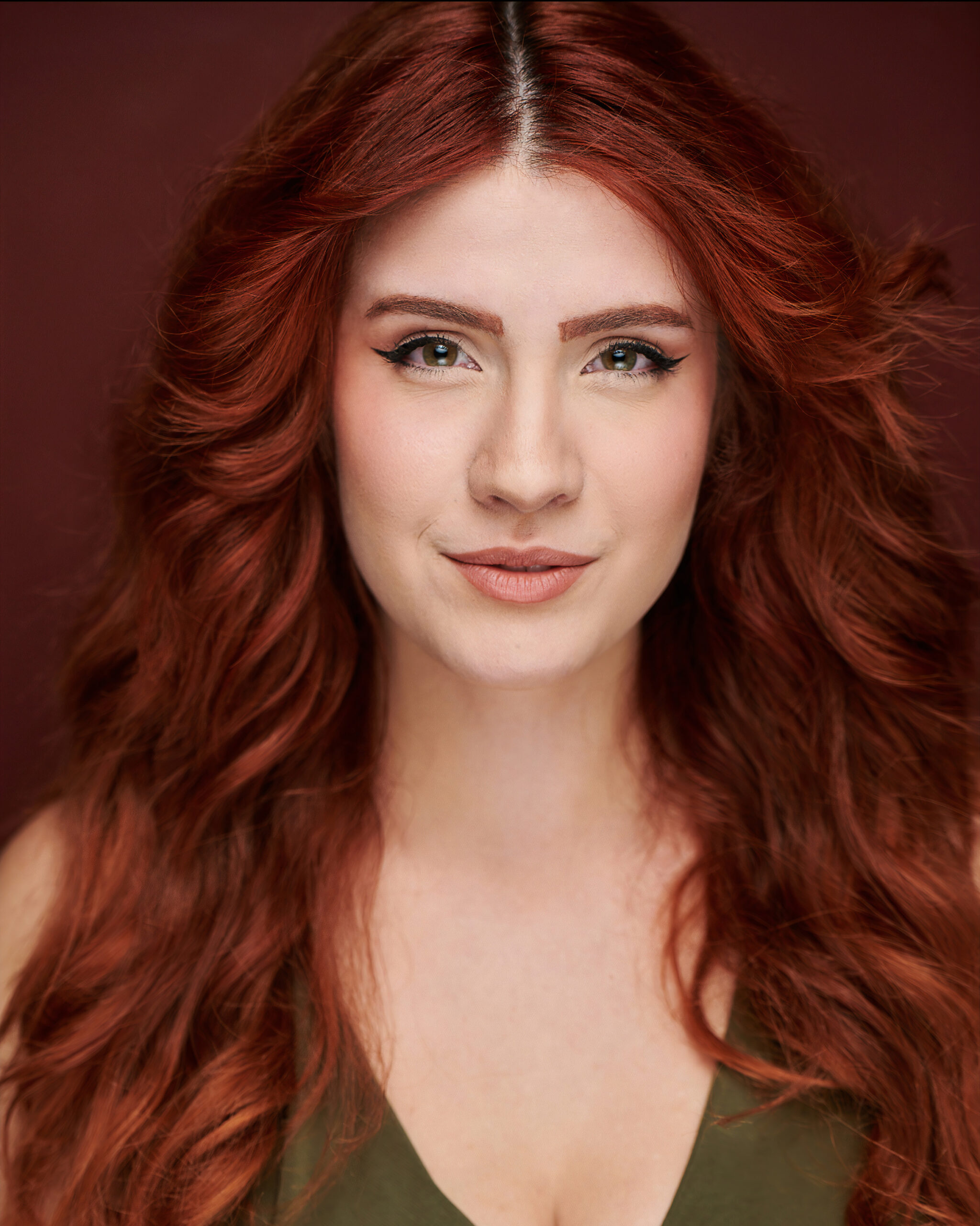 Smizing headshot in green top